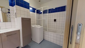 A bathroom with a shower, a toilet, a sink, and a mirror. - kiener 75m2 city center      3br (Colmar)
