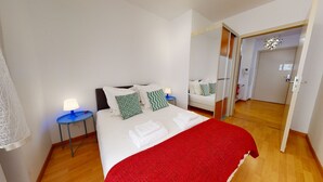 A hotel room with a bed, two bedside tables with lamps, a red throw blanket, and a mirror. - kiener 75m2 city center      3br (Colmar)