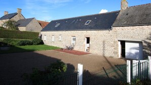 A stone building with a sloped roof, a small garden area, and a fenced driveway. - Charming 2-Bedroom House with Garden, BBQ, and Fireplace in Vicq-sur-Mer (Vicq-sur-Mer)