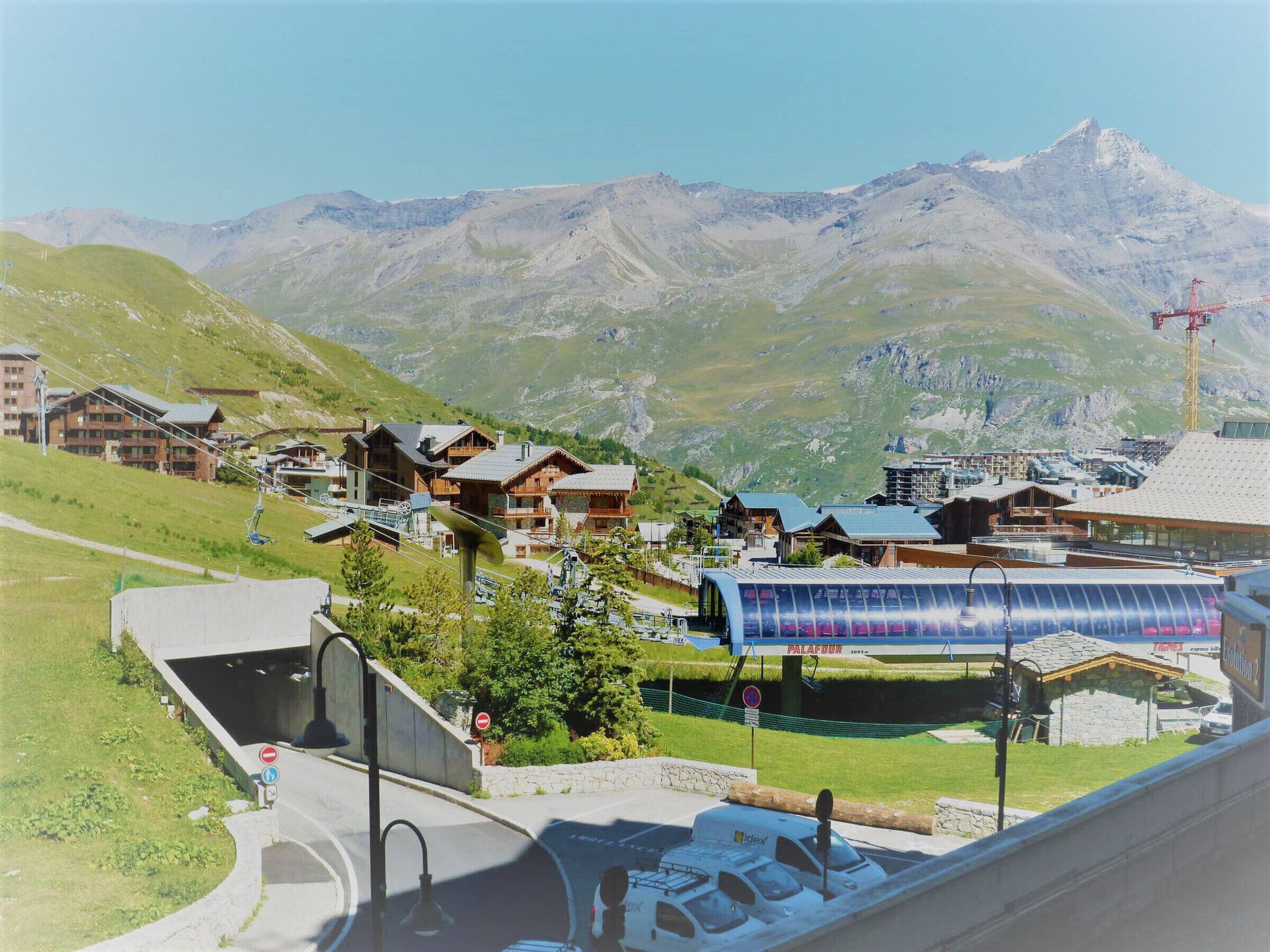 A mountain resort with chalet-style buildings, a ski lift, and a modern glass structure.