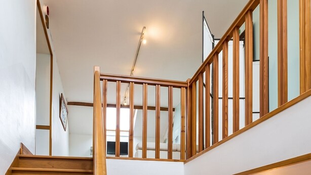 Un escalier avec des marches en bois et une rampe en bois menant à l’étage supérieur.