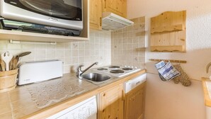 Cozinha com armários de madeira, máquina de lavar louça Bosch, micro-ondas e pia.
