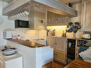 A kitchen with a microwave, stove, and various kitchen items on the counter.