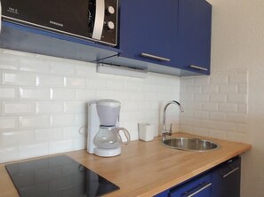 Modern kitchen with stainless steel sink, microwave, and coffee maker.