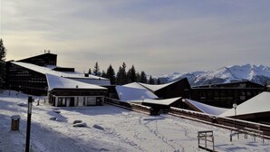 A snow-covered ski resort with buildings and a mountain backdrop. - Ski-in/ski-out studio for 4 in Arc 1800 with balcony (Les Arcs 1800)
