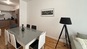 Eine moderne Küche mit Essbereich, einer schwarzen Lampe und einem gerahmten Bild an der Wand.
