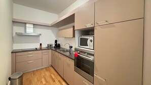Eine kleine Küche mit Mikrowelle, Backofen und Kaffeemaschine.