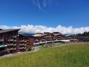 Un hotel con varios pisos, balcones y una zona de restaurante.