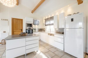 A modern kitchen with white cabinetry, a built-in oven, microwave, and a Samsung refrigerator.