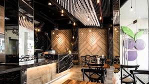 Un intérieur de restaurant moderne avec un plancher en bois, un comptoir en marbre et des murs décorés d’un motif en chevrons.
