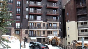 A multi-story hotel with balconies, a stone facade, and a ski lodge entrance. - 3-room apartment for 6 with pool, pets allowed in Risoul 1850 (Risoul)
