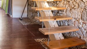 Un escalier en bois avec un mur de pierre en arrière-plan.