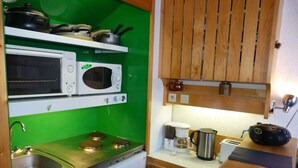 A compact kitchen with a microwave, oven, sink, and a coffee maker. - Ski-in duplex for 5 in Charmettoger with WIFI (Les Arcs 1800)