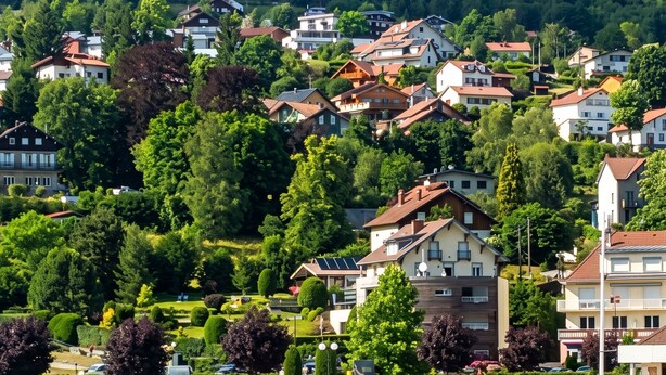 A coastal town with residential buildings, a marina with boats, and a hilly backdrop. - Homerez - Spacious House in Gérardmer (Gérardmer)