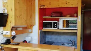 A compact kitchen with wooden cabinets, a microwave, a toaster, and a sink. - Duplex 2 Rooms - 5 Pers, Charmettoger Arc 1800, Pets Allowed (Les Arcs 1800)