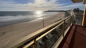 Een balkon met uitzicht op een strand en de oceaan.
