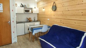 A compact kitchen with a microwave, sink, and wooden wall paneling. - 2-room apartment, 4 beds in Cauterets near thermal baths (Cauterets)