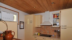 Una cocina con armarios de madera, salpicadero de azulejos y encimera de madera.