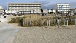 En byggnad vid kusten med flera balkonger, en grusgång och ett trästaket.