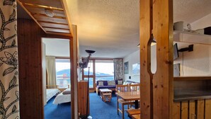 Ein gemütliches Zimmer mit Bett, einer Couch, einem Esstisch und einem Fernseher.