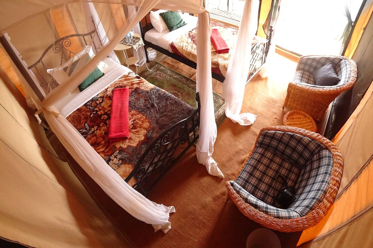 A cozy room with a bed, a chair, and a small table.