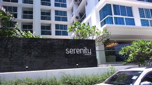 A modern building with a black wall featuring the name 'serenity' and 'by nova'. - Serenity Wongamat Pattaya Studio (Pattaya)