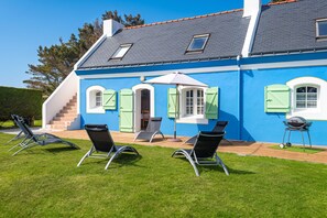 A house with a blue exterior, a grey roof, and a small porch with two chairs and a table. - Homerez - House in Bangor (Bangor)