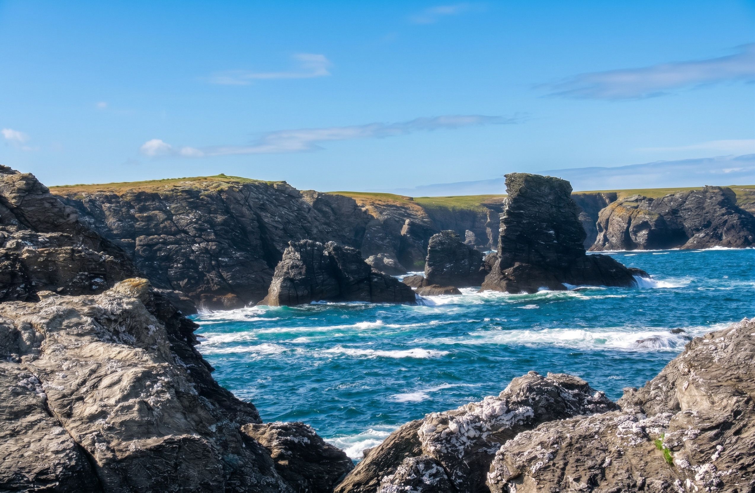 Eine Küstenlandschaft mit schroffen Klippen und dem Meer.