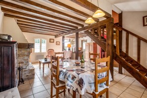 A dining area with a wooden table set for two, a bottle of wine, and a magazine. - Homerez - House in Bangor (Bangor)