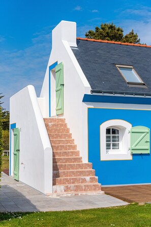 A house with a steeply pitched roof, a small window with a white frame, and a green door. - Homerez - House in Bangor (Bangor)