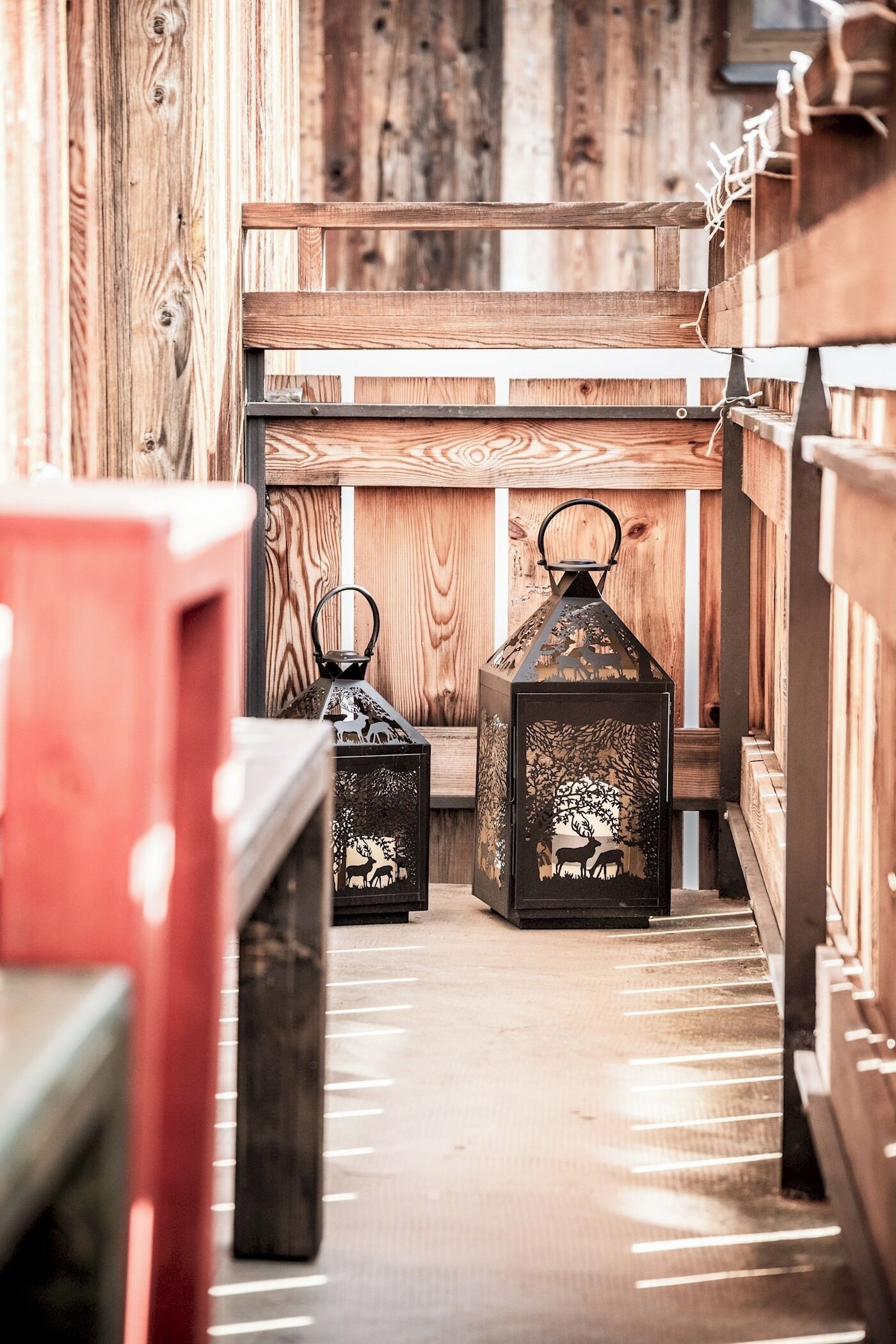 A wooden interior with benches and lanterns.
