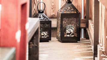 A wooden interior with benches and lanterns.