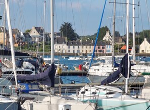 A marina with boats docked, a clear sky, and buildings in the background. - Homerez - House in Camaret sur Mer (Camaret sur mer)