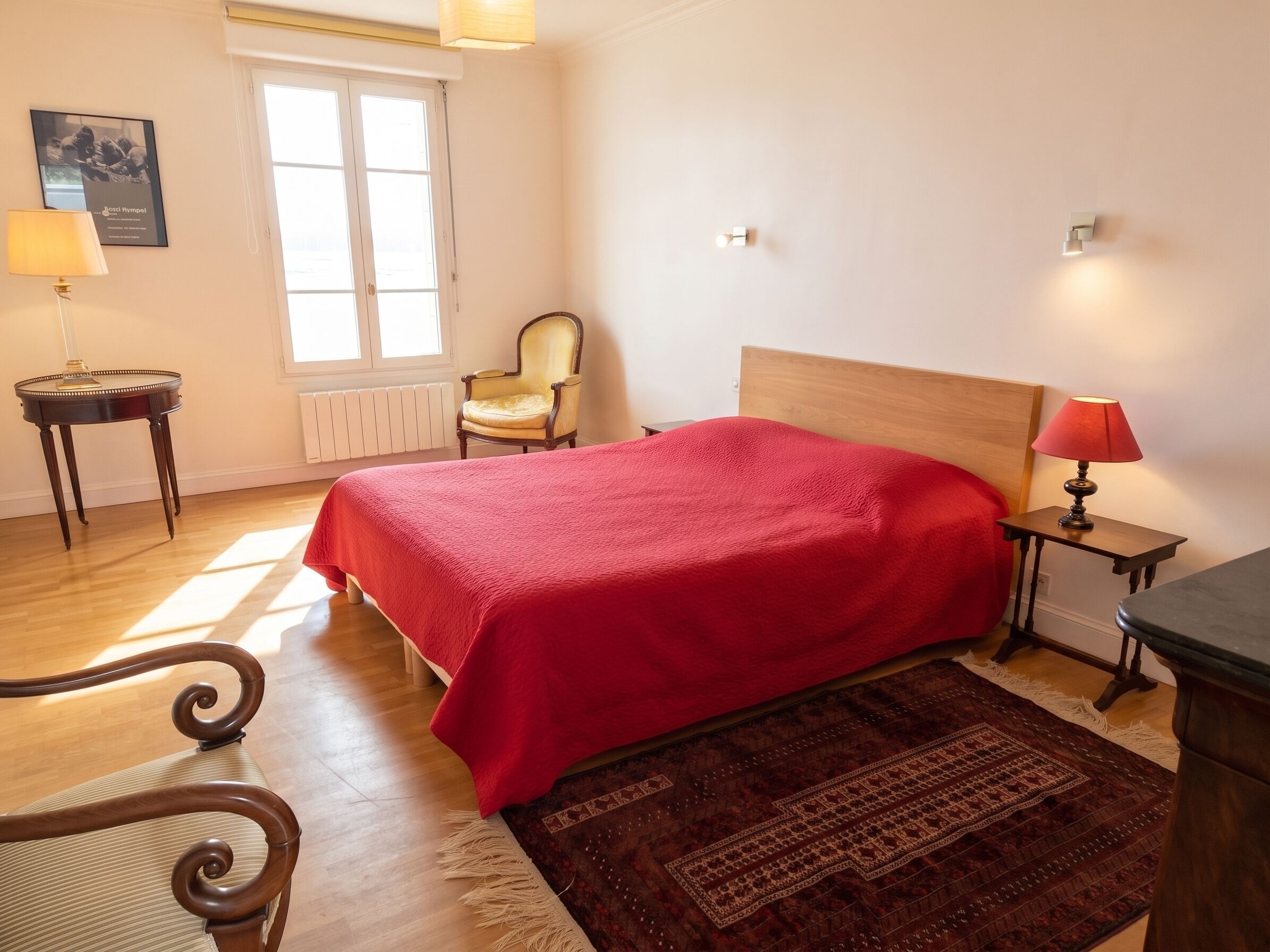 A bedroom with a bed, a chair, a lamp, a radiator, and a window.
