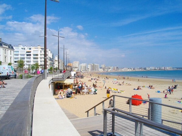 A beachside promenade with a view of the beach and ocean.