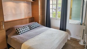 A bedroom with a bed, a wardrobe, a window with curtains, and a mirror. - Close to the beach, flat 3/4 persons  et  mooring (PORT GRIMAUD)