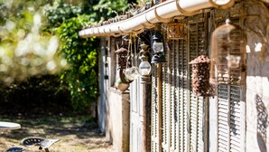 A rustic building with a series of hanging lanterns and a metal gate. - L' OUSTAOU LES FORTUNES 3-star Provence farmhouse (Ansouis)
