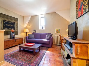 A cozy living room with a sofa, coffee table, and a television. - Homerez - Apt. central Saumur, city view (Saumur)
