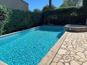 A rectangular swimming pool with clear blue water, surrounded by a stone deck and dense greenery. - Homerez - Villa in Saint-Raphaël (Saint-Raphaël)