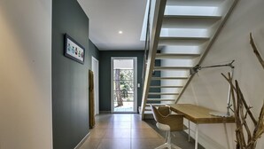 A modern interior with a staircase, a desk, and a framed picture on the wall.