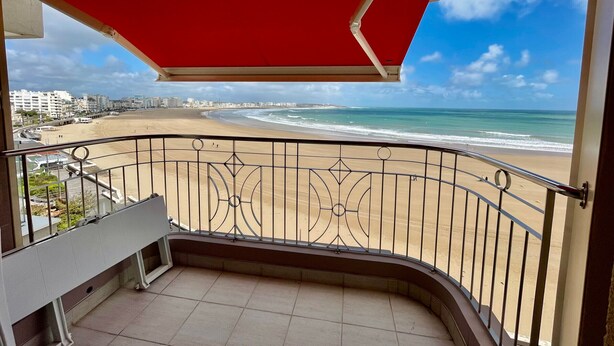 Een balkon met uitzicht op een strand en de oceaan.