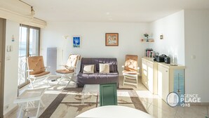 Een woonkamer met een bank, stoelen, een salontafel en een kast.
