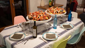 A dining table set with plates, cutlery, wine glasses, and a bottle of wine. - Homerez - Villa Soulac-sur-Mer (Soulac-sur-Mer)