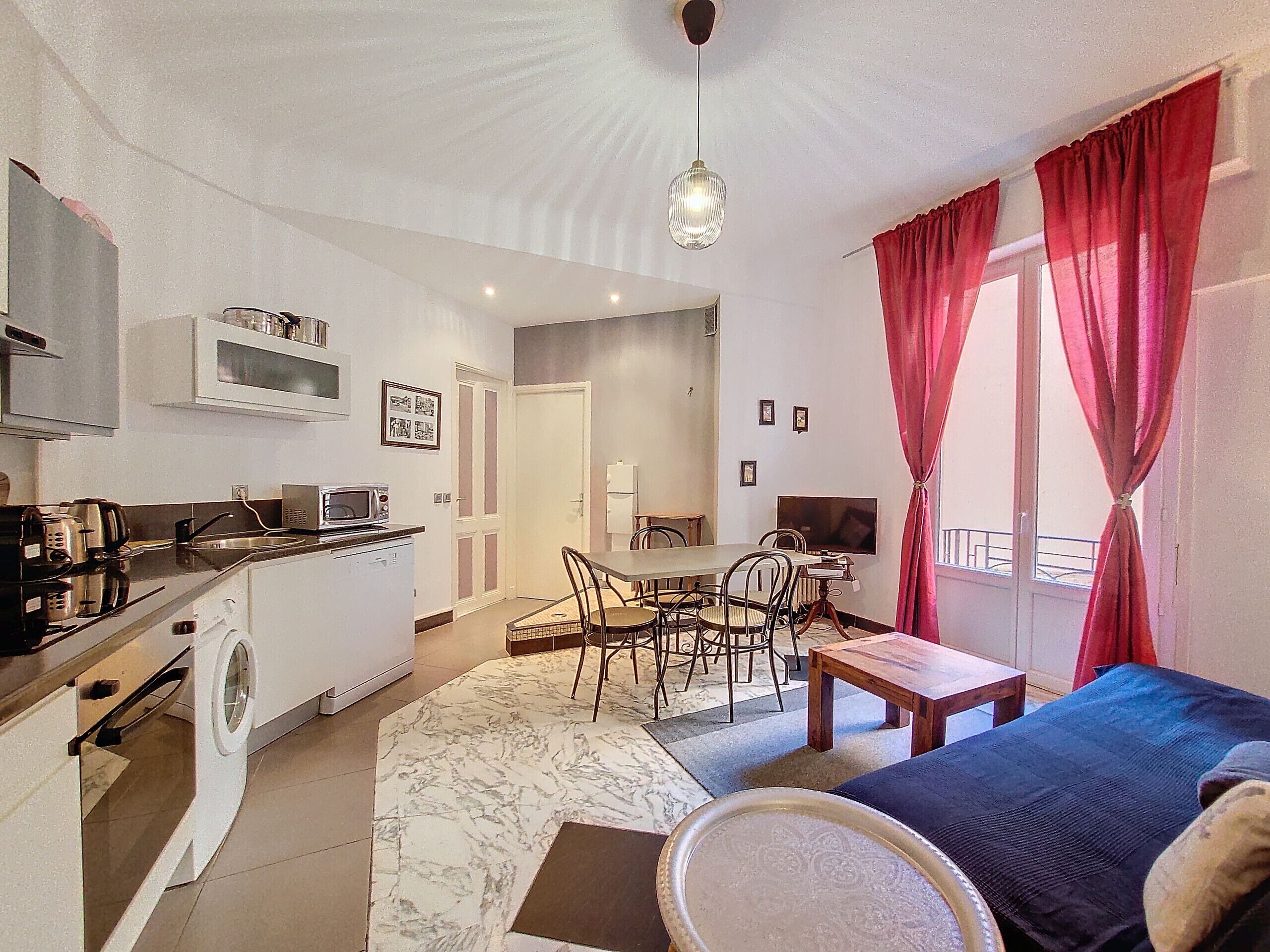 A compact living space with a kitchenette, dining area, and a sofa.