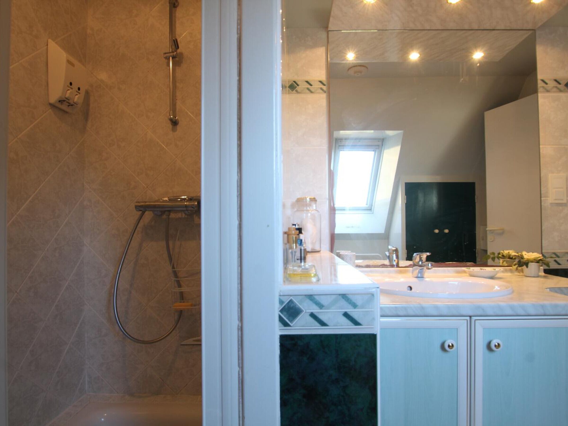 A bathroom with a shower, a sink, and a mirror.
