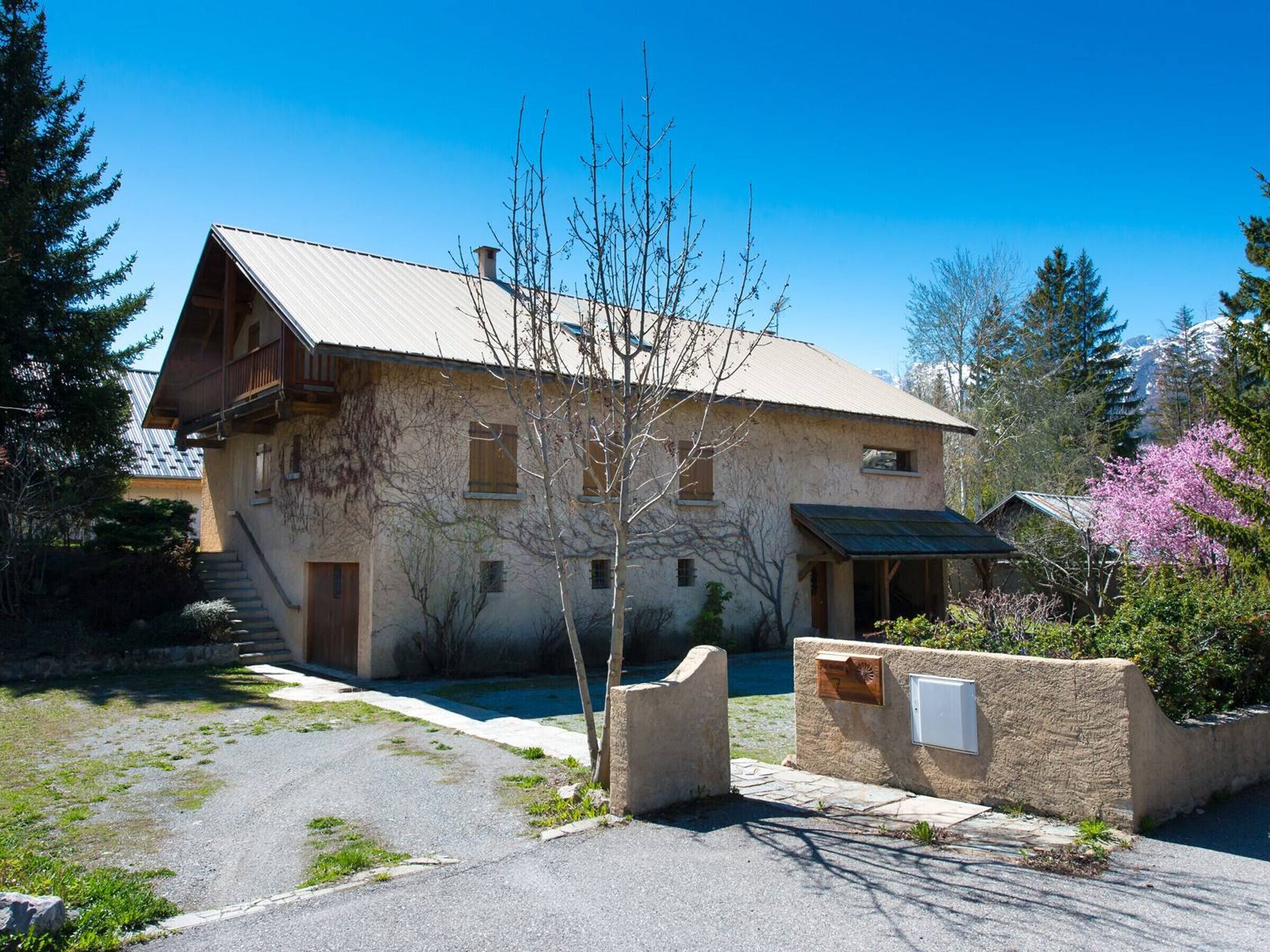 A rustic mountain cabin with a sloped roof, wooden exterior, and a stone entrance.