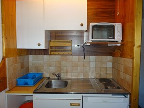 A compact kitchen with a sink, a microwave, and a small countertop.
