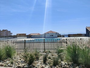 Surrounded by lush greenery and a rocky landscape, this property offers a serene swimming pool with a wooden fence.