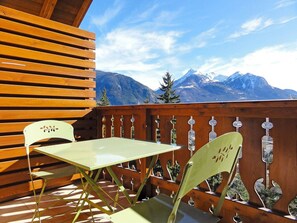 A wooden deck with a table and chairs, overlooking a mountainous landscape. - Beautiful 67m² apartment, 2 bedrooms, parking, south-facing balcony - Briançon (Briançon)