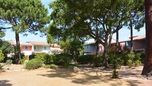 A residential area with houses, trees, and a gravel path. - MINI-VILLA SAINT CYPRIEN C20- 3***-QUIET (Saint-Cyprien Lecci)